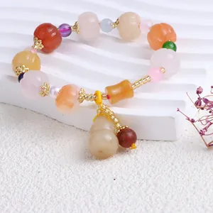 Detailansicht eines Armbands aus natürlicher Goldseidenjade mit Kürbis-Anhängern