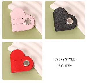 Close-up of heart-shaped PU leather cable winders in pink, black, and red colors