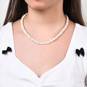 Détail élégant d'un collier de perles d'eau douce baroques naturelles porté par un mannequin.
