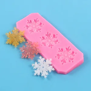 Detailed view of pink snowflake silicone mold with colorful finished resin decorations
