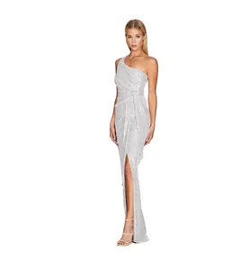 Detail of a silver one-shoulder sequin maxi dress with high slit and waist drape.