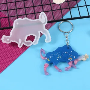 Close-up detail of Taurus constellation resin mold with finished blue glitter keychain