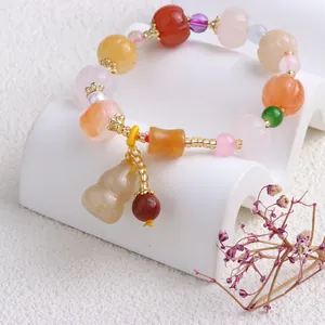 Detailaufnahme eines bunten Armbands aus natürlicher Jade mit Kürbis- und Hulu-Perlendesign.