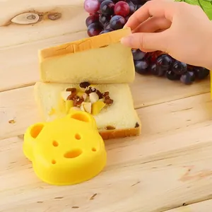 Moule à sandwich en forme d'ours jaune avec pain et garniture aux fruits sur bois