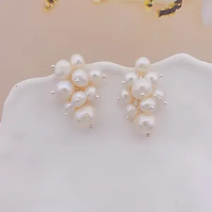 Detail shot of cluster freshwater pearl grape earrings on a white ceramic plate.