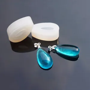 Vue rapprochée de moules en silicone goutte avec des pendentifs en résine cyan finis