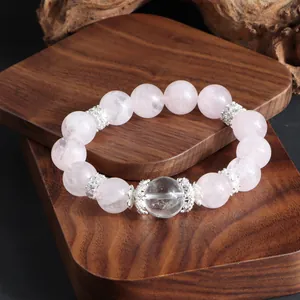 Gros plan montrant la texture des perles de quartz rose et de cristal blanc sur bois