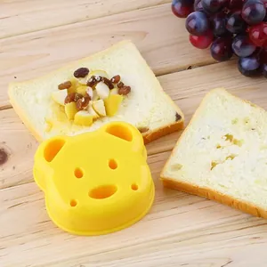 Moule à sandwich en forme d'ours pour petit-déjeuner créatif sur table en bois.