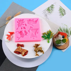 Close-up of pink silicone Christmas mold with reindeer and bell shaped decorations