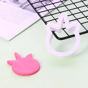 Detailansicht eines weißen Keks-Ausstechers mit einem geformten rosa Fondant-Stück