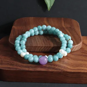 Detailopname van een dubbel-laags kralenarmband met blauwe kristallen en parels.