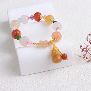 Nahaufnahme eines Jinsi Jade Armbands mit Kürbisperlen und einem Gourd-Anhänger