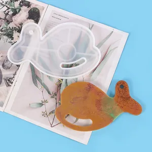 Detail shot of a whale-shaped silicone mold and finished resin coaster DIY kit.