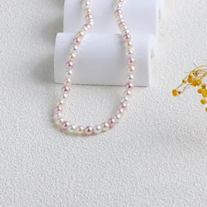 Détail de collier de perles rose et blanc aux couleurs bonbons avec un lustre lisse