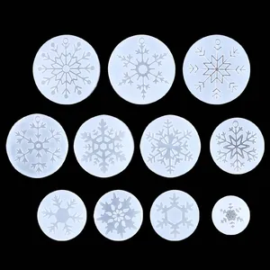Detalle de once moldes de silicona con patrones de copos de nieve para crear colgantes DIY.