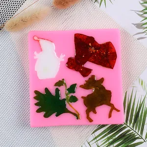 Close-up of pink Christmas silicone mold featuring elk and holly leaf designs with resin fill