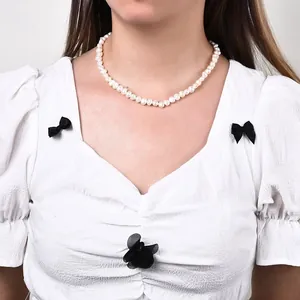 Vue détaillée d'un collier de perles d'eau douce baroques vintage sur le cou d'un mannequin femme