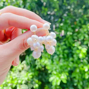 Detailed close-up shot of elegant grape-shaped freshwater pearl cluster dangle earrings