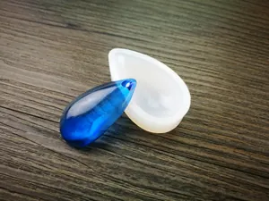 Vue macro d'un moule en silicone goutte d'eau avec un pendentif en résine bleue