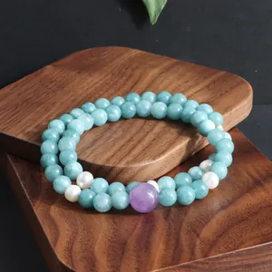 Detail van dubbele streng kristallen armband met aquamarijn en paarse kunziet kralen