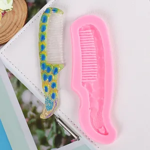 Detailed view of pink silicone comb mold with finished peacock design resin comb