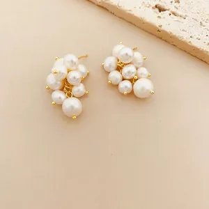 Detail of elegant freshwater pearl grape cluster stud earrings in gold finish.