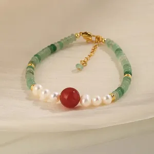 Handcrafted bracelet with green aventurine, white pearls, and a central red agate bead.