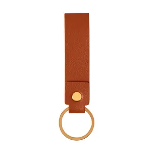Porte-clés minimaliste en cuir PU marron avec un anneau en métal doré et un rivet.