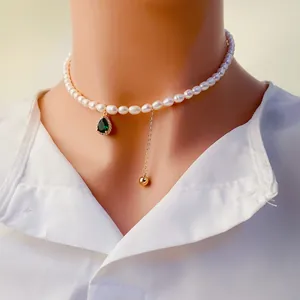 Collier élégant en perles d'eau douce avec pendentif zircon vert et gland doré raffiné