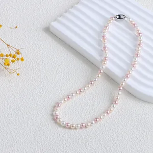 Détail d'un collier de perles de nacre élégant aux couleurs de bonbons roses et blanches