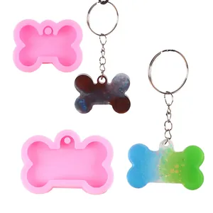 Detailed view of bone-shaped silicone molds and finished resin glitter keychains
