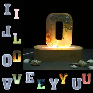 Detail of alphabet resin molds and a finished glittery letter O on an LED light base