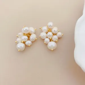 Detailed close-up of grape-shaped freshwater pearl cluster stud earrings in a gold tone finish