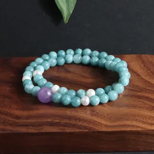 Elegant dubbelstrengs armband met groene jade kralen, paarse kunziet en parels op hout.