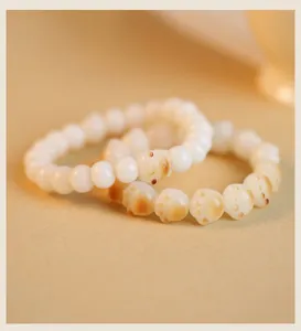 Detail view showing cat paw beads on a handmade natural white Bodhi root bracelet