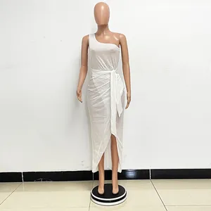 Detail view of a white one-shoulder sequin dress featuring a pleated waist tie and slit.