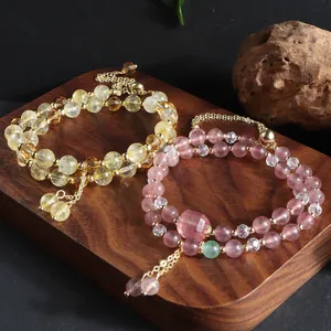 Detailed view of natural citrine and strawberry quartz double-layer beaded bracelets.