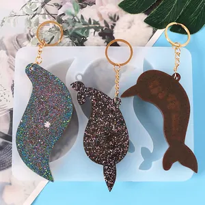 DIY silicone mold for resin keychains featuring finished glitter dolphin and whale charms