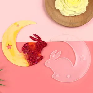Macro view of a moon and rabbit silicone mold next to a glittery resin finished piece