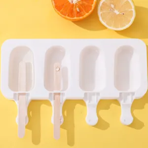 Close-up of a white 4-cavity silicone popsicle mold with wooden sticks on yellow background