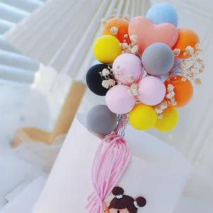 Primer plano de adorno para tarta con globos de goma suaves de colores y flores secas