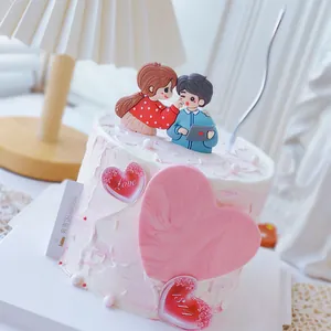 Dettaglio di statuine romantiche per coppia e topper per torta a forma di cuore per feste.