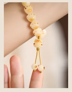 Detailed macro shot of cat paw shaped white Bodhi root beads on an elegant bracelet