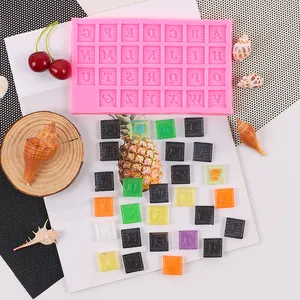 Détail du moule à lettres en silicone rose et blocs de lettres en fondant colorés