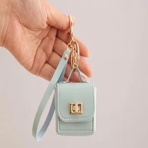 Handgehaltener mintgrüner Mini-Taschen-Schlüsselanhänger aus PU-Leder für Kopfhörer-Zubehör