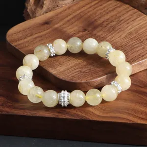 Primer plano detallado de la pulsera de cuarzo rutilado dorado con cuentas espaciadoras de plata