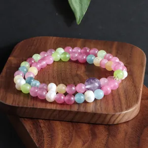 Detail van een dubbele armband met natuurstenen en zoetwaterparels op een houten plateau
