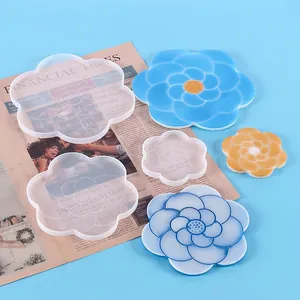 Close-up of camellia-shaped silicone molds and finished resin flower coasters.