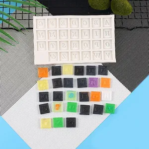 Vue détaillée d'un moule en silicone de 26 lettres et de pièces en résine colorées