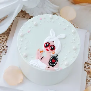 Dettaglio di un topper per torta regina con occhiali da sole su una torta verde